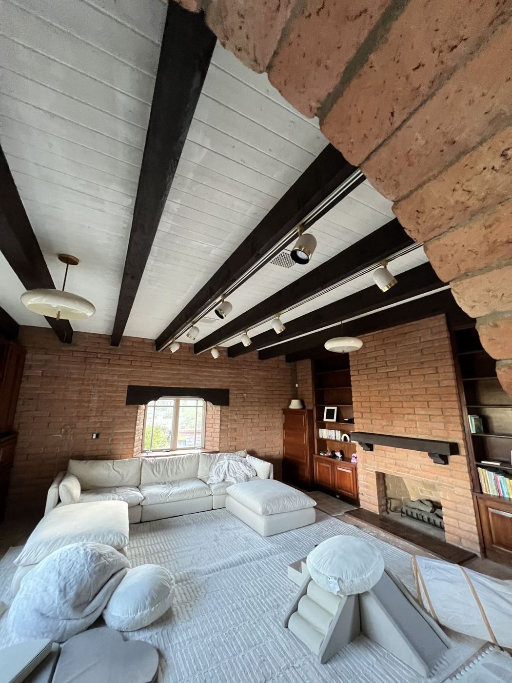 Living room with freshly painted white wood beam ceiling