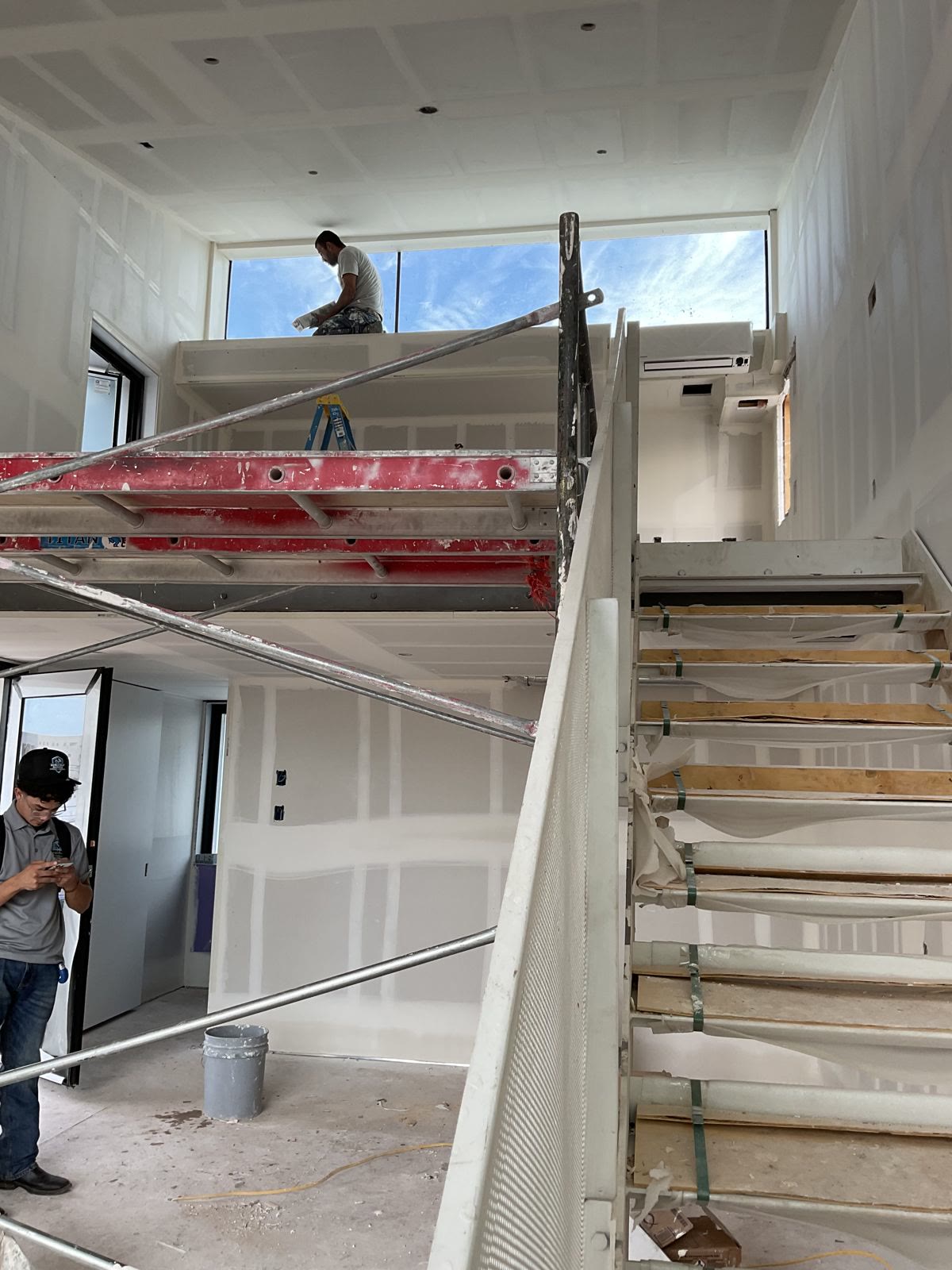 Two-story interior with drywall repairs prepped for paint