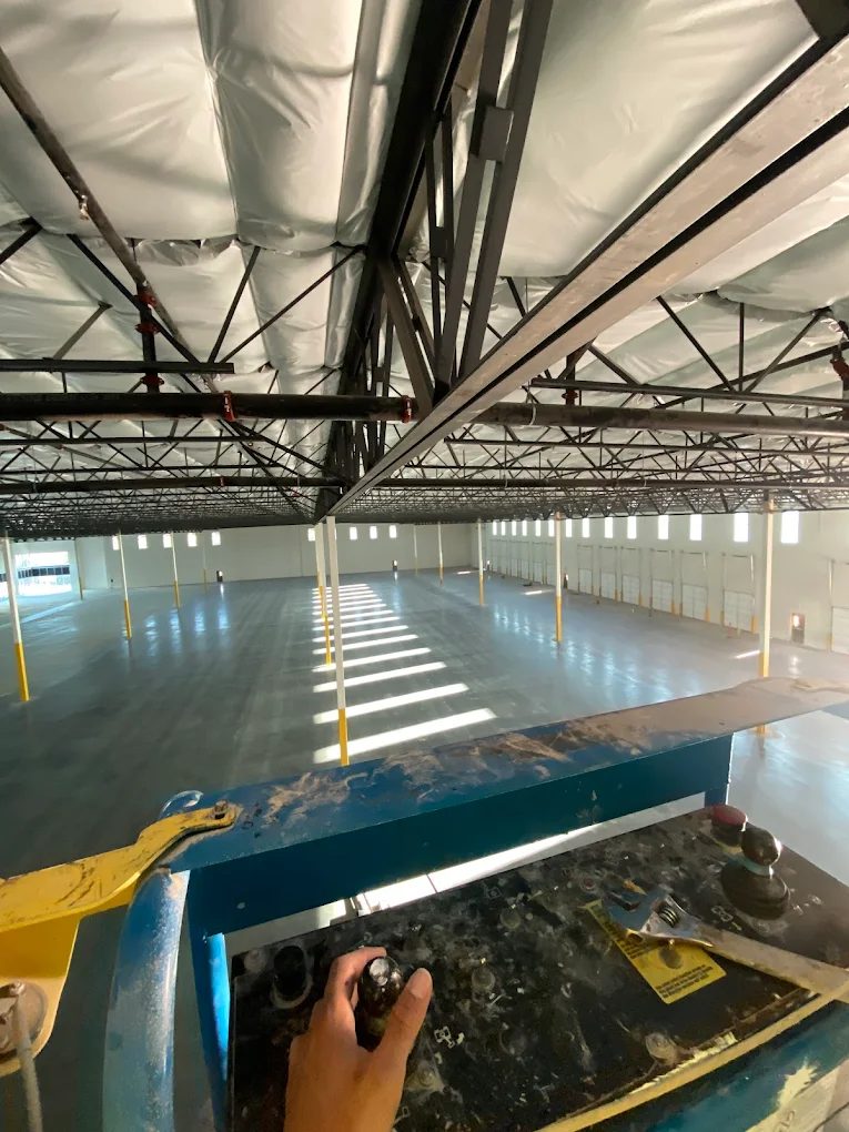 Painting a warehouse ceiling from a lift