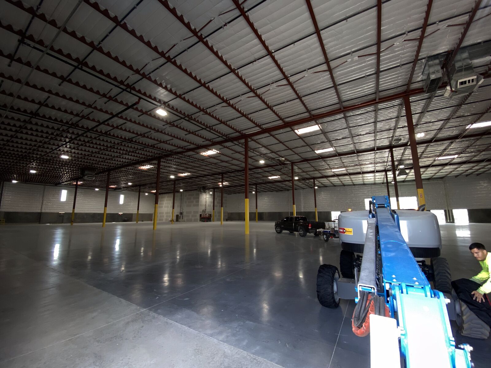Shield Coat crew painting a warehouse interior from a boom lift in Phoenix